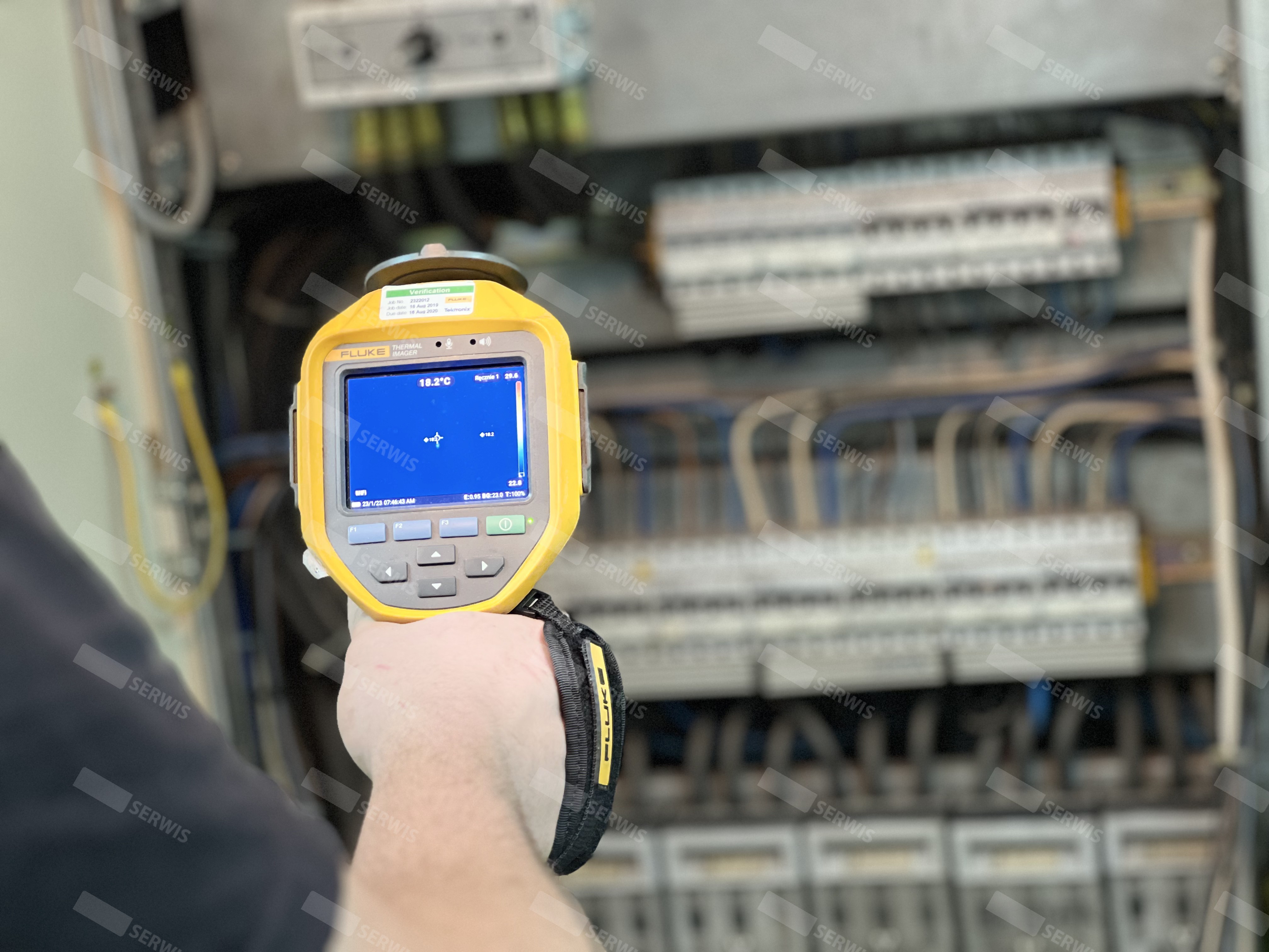 Technik wykonujący przegląd termograficzny rozdzielnicy elektrycznej