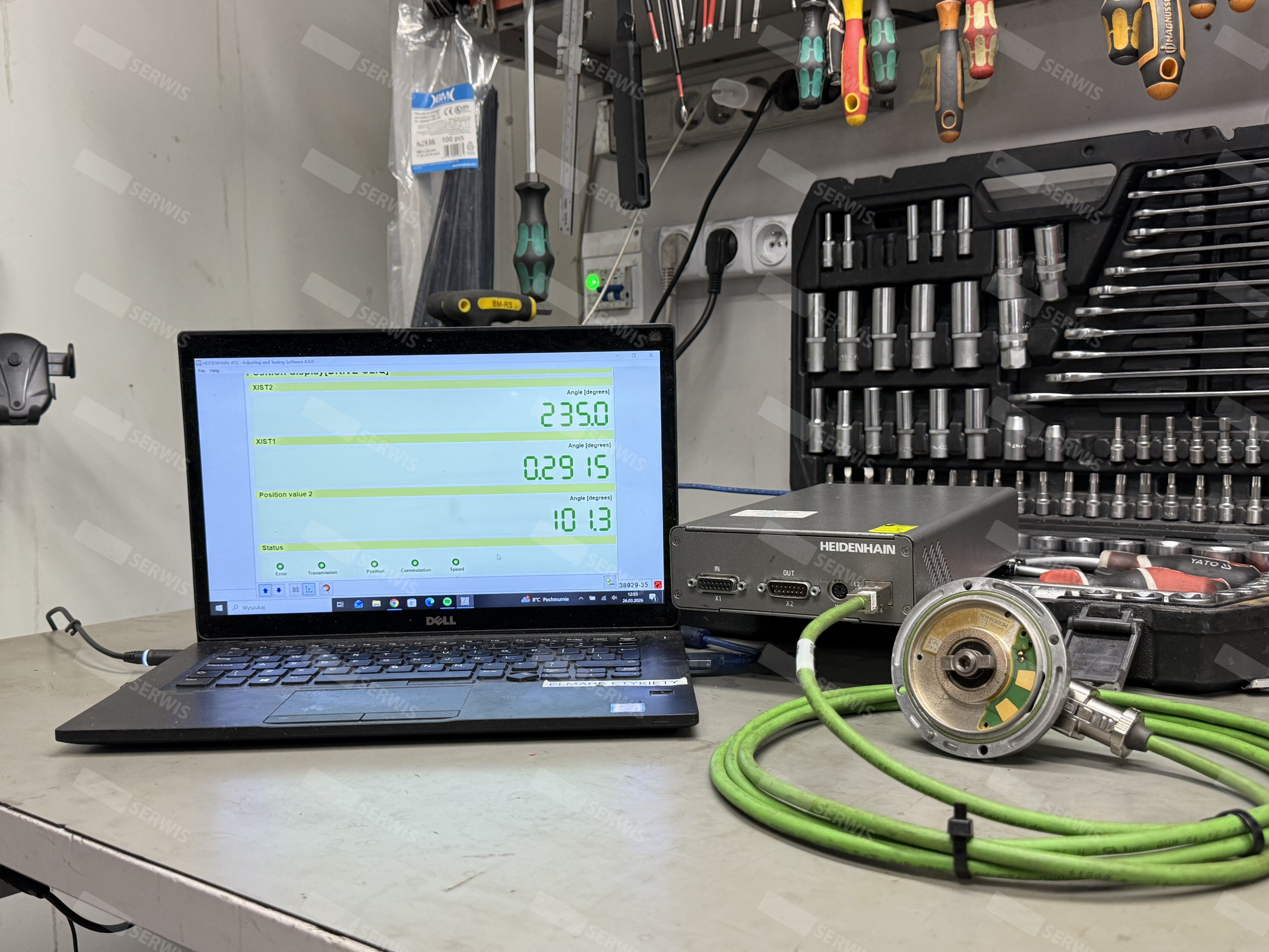 Laptop Dell z oprogramowaniem diagnostycznym obok serwosilnika Heidenhain na stole warsztatowym