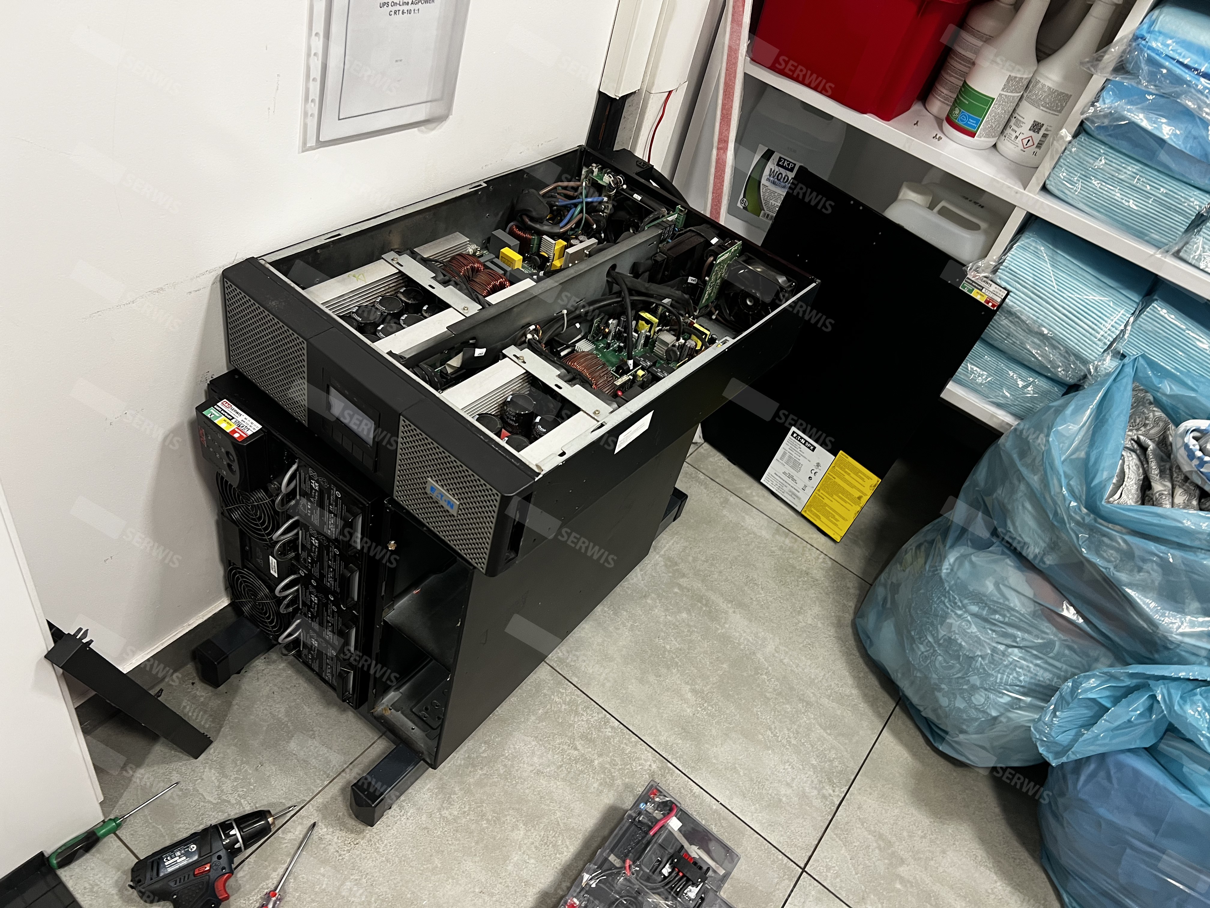 Serwis UPS z otwartą obudową, widoczne komponenty wewnętrzne do przeglądu technicznego