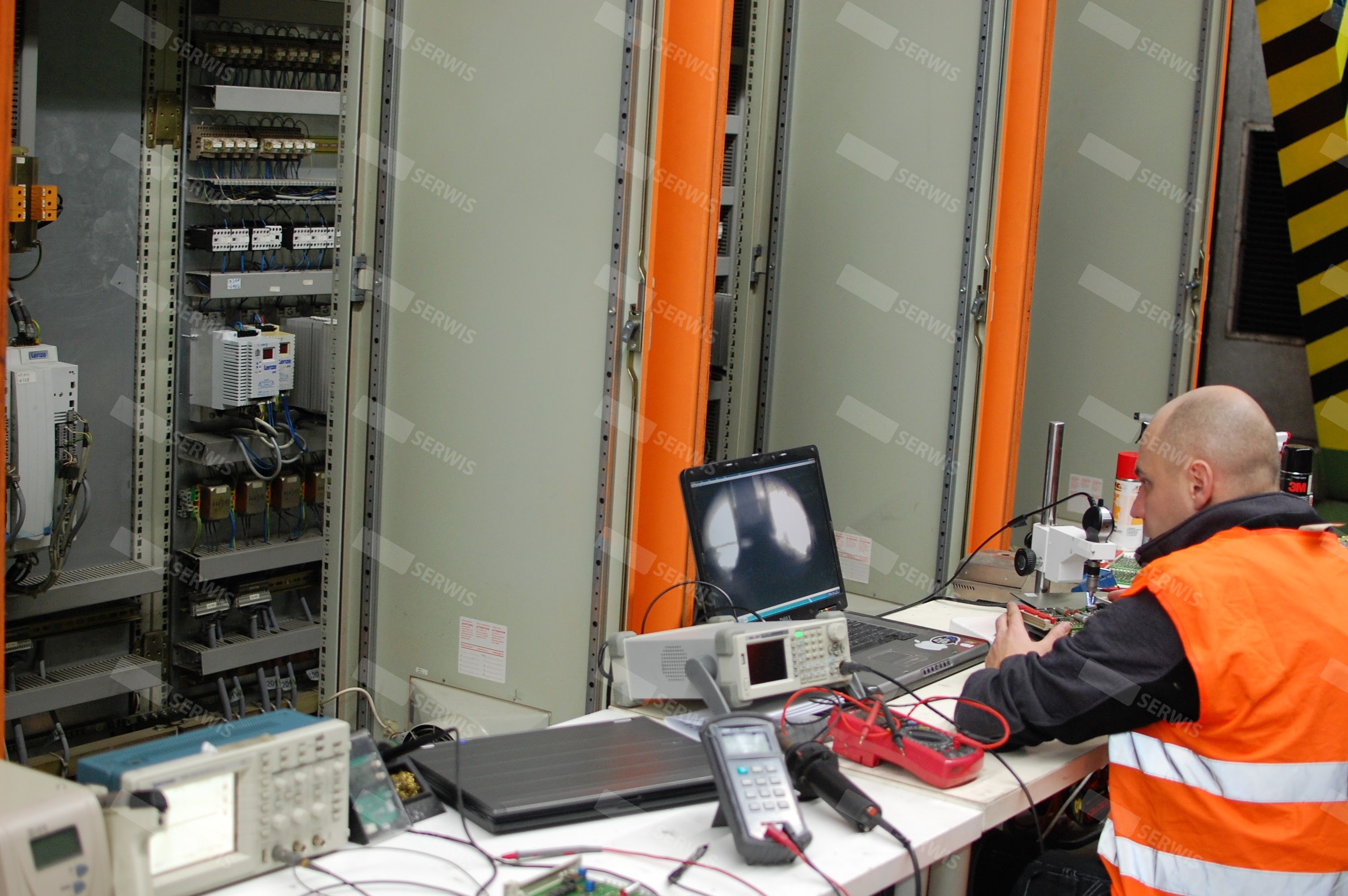 Technik w kamizelce odblaskowej testujący systemy elektryczne w serwerowni