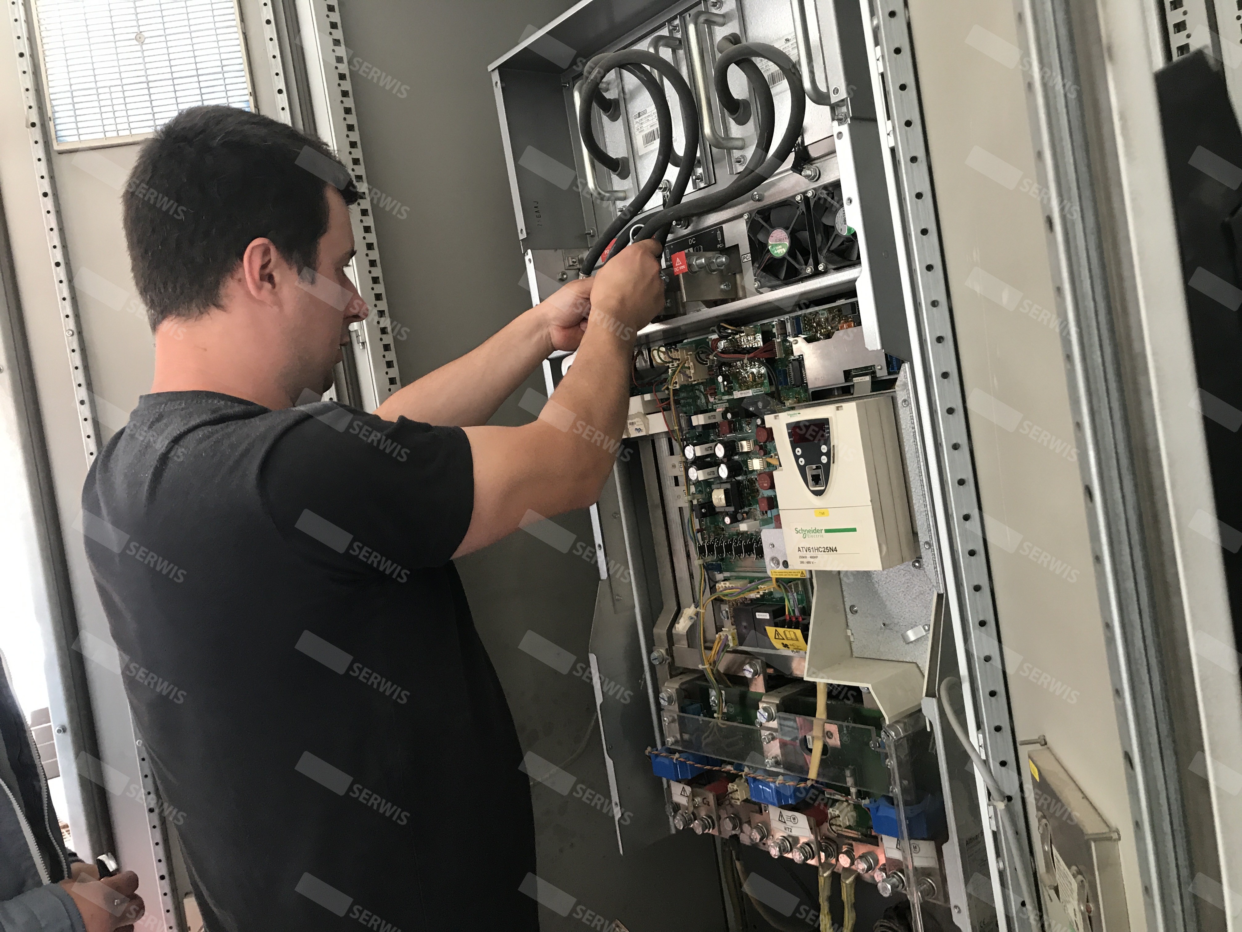 Technik serwisujący panel sterowania w szafie elektrycznej