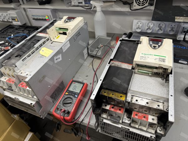 Falowniki przemysłowe Schneider Electric na stanowisku serwisowym z multimetrem